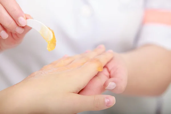 Schoonheidsspecialiste toepassing hydraterende crème op client handen. Beauty salon — Stockfoto