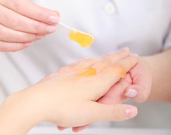 Estetista applicare crema idratante sulle mani del cliente. Salone di bellezza — Foto Stock