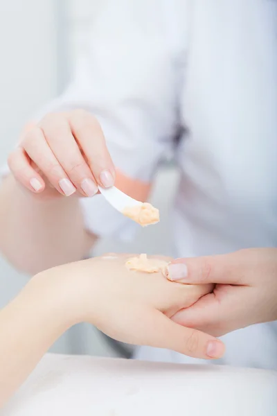 Schoonheidsspecialiste toepassing hydraterende crème op client handen. Beauty salon — Stockfoto
