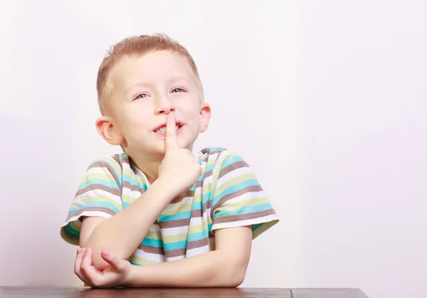 Porträt eines fröhlich lachenden blonden Jungen am Tisch — Stockfoto