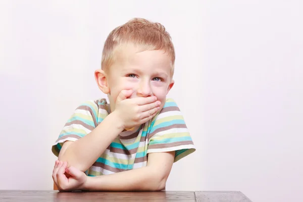 Porträt eines fröhlich lachenden blonden Jungen am Tisch — Stockfoto