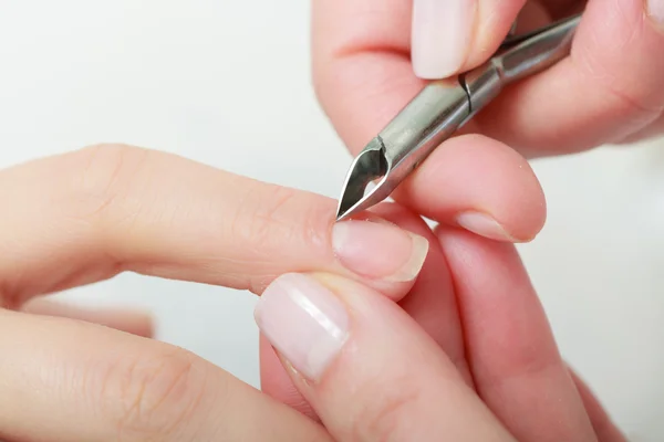 Kosmetikerin trimmt Nagelhaut einer Kundin im Schönheitssalon — Stockfoto