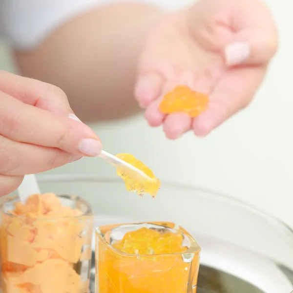 Esthéticienne à la crème hydratante orange. Soins de la peau. Salon de beauté . — Photo