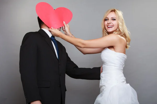 Portrait de mariée heureux et marié avec coeur rouge sur gris — Photo