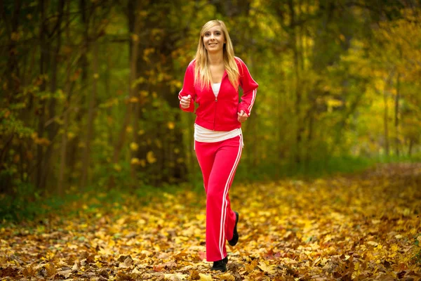 Girl running jogging in autumn fall forest park — Stock Photo, Image