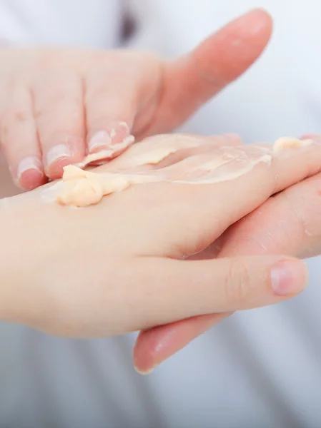 Esteticista aplicando creme hidratante nas mãos do cliente. Salão de beleza — Fotografia de Stock