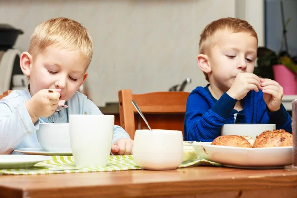 Garçons enfants enfants manger des flocons de maïs petit déjeuner repas à la table — Photo