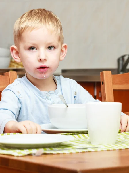 Boy kid child eating corn flakes breakfast meal at the table — Stock Photo, Image