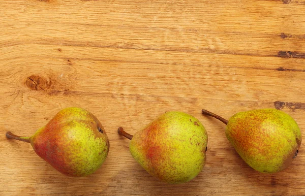 Drei Birnen Früchte auf Holztischhintergrund — Stockfoto