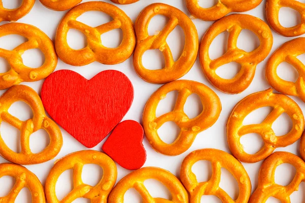 Valentine's day background pretzels pattern and red heart. — Stock Photo, Image