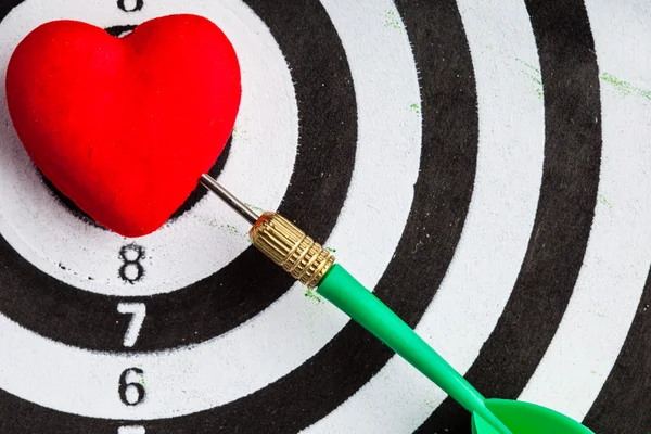 Bullseye としてハートの愛の記号で dart が黒白いターゲット — ストック写真