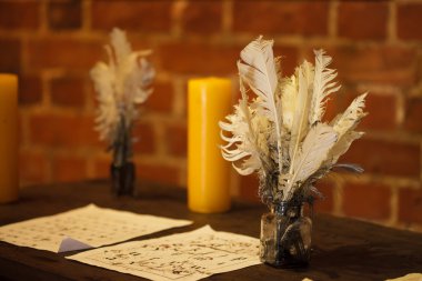 Feather quill pens candle and old paper on wooden desk. Vintage. clipart