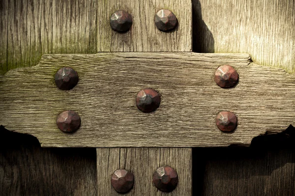 Old wooden background with metal rivets vintage door detail — Stock Photo, Image