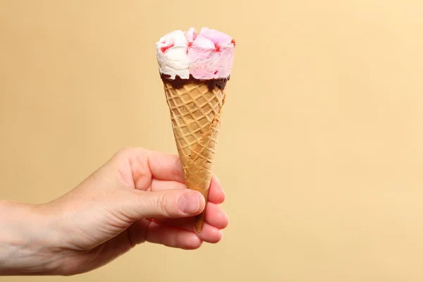 Berry icecream cone in hand on orange — Stock Photo, Image