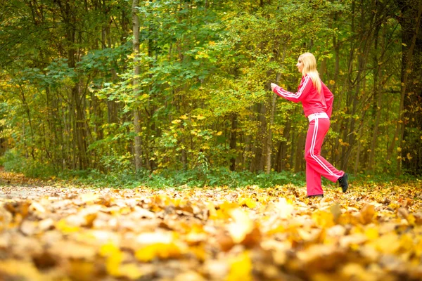 Menina loira jovem correndo jogging no outono queda floresta parque — Fotografia de Stock