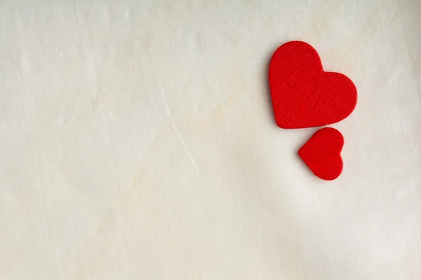 Corazones decorativos rojos de madera sobre fondo de tela blanca . — Foto de Stock