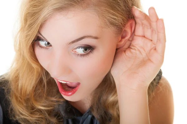 Blonde surprised gossip girl with hand behind ear listening secret — Stock Photo, Image
