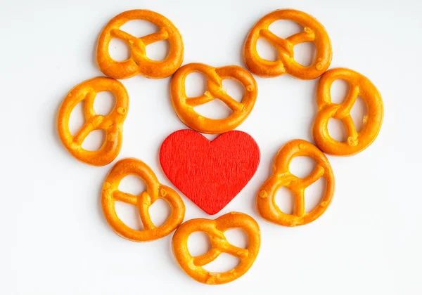 Pretzels e coração vermelho sobre fundo branco — Fotografia de Stock