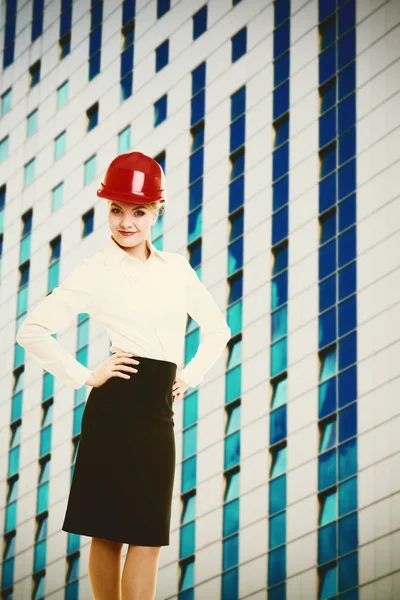 Inżynier kobiece kobieta w czerwony kask i nowoczesny budynek — Zdjęcie stockowe