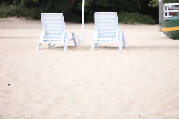 Kum plajı üzerinde beyaz havuzu koltukları — Stok fotoğraf