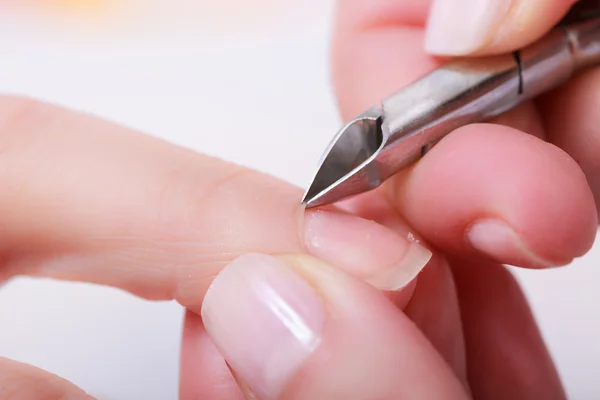 Kosmetikerin trimmt Nagelhaut einer Kundin im Schönheitssalon — Stockfoto