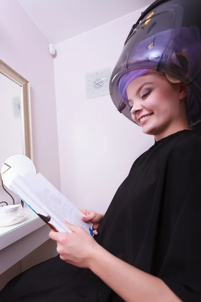 Woman hair rollers curlers reading magazine hairdryer beauty salon — Stock Photo, Image