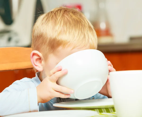 Menino criança comendo flocos de milho café da manhã refeição da manhã em casa . — Fotografia de Stock