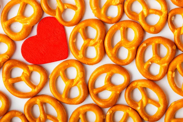 Valentine's day background pretzels pattern and red heart. — Stock Photo, Image