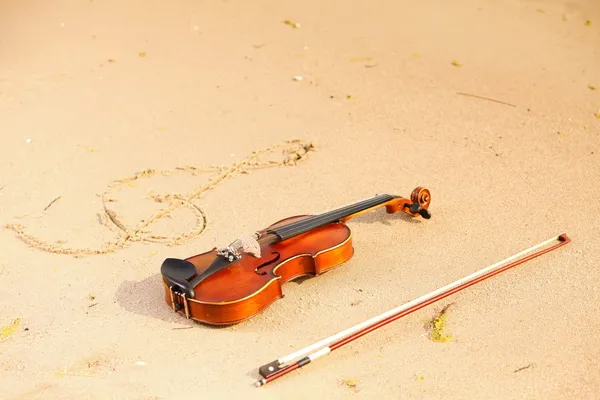 Violino e chiave sulla spiaggia. Concetto musicale — Foto Stock