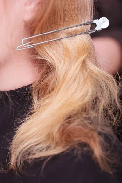 Vrouwelijke blond haar met een haarspeld pin. vrouw door Kapper in beauty salon — Stockfoto