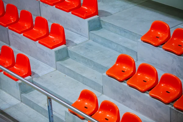 Primer plano de los asientos del estadio deportivo rojo. Parada vacía. Patrocinador de deportes de equipo —  Fotos de Stock