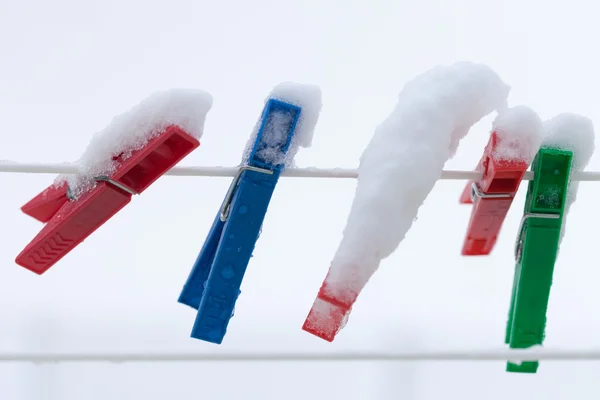 Clip colorati lavaggio biancheria coperta striscia di neve corda all'aperto. Inverno . — Foto Stock