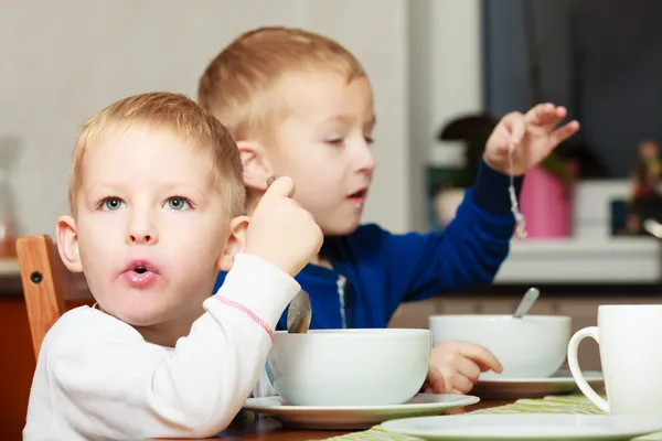 Τα παιδιά παιδιά αγόρια που τρώνε νιφάδες καλαμποκιού πρωινό γεύμα στο τραπέζι — Φωτογραφία Αρχείου