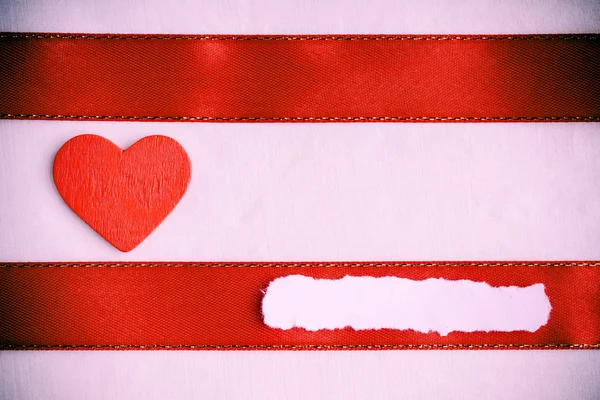 Fondo del día de San Valentín. Cinta y corazón de satén rojo . — Foto de Stock