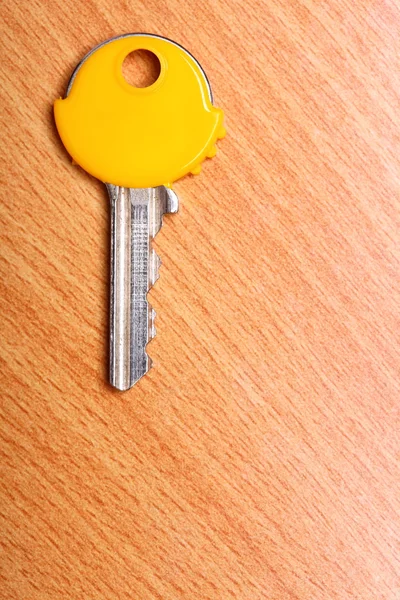Chave da casa com casacos de plástico amarelo bonés na mesa — Fotografia de Stock