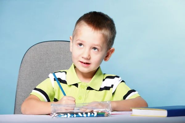 Young cute boy draws with color pencils Royalty Free Stock Images