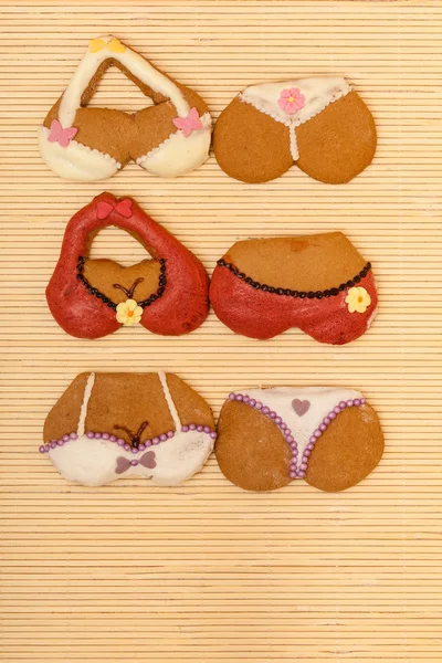 Divertido bikini colorido forma de galletas de pan de jengibre en la estera de bambú —  Fotos de Stock