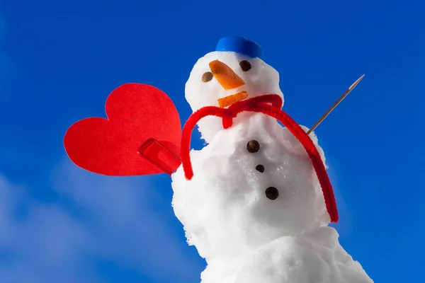 Pequeño feliz Navidad muñeco de nieve corazón rojo amor símbolo al aire libre. Invierno. —  Fotos de Stock