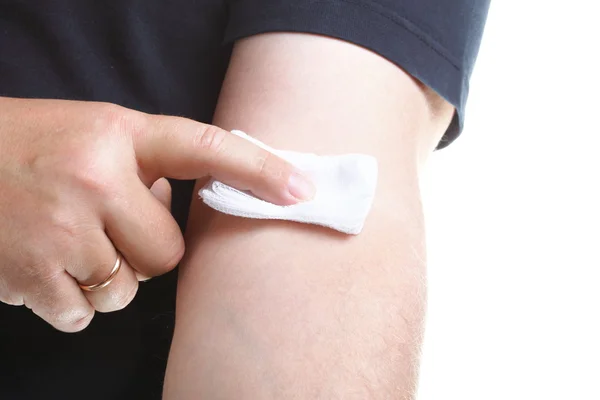 Appying a swab to an arm after blood sample — Stock Photo, Image