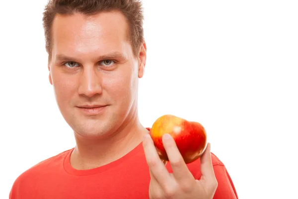 Happy man in red shirt holding apple. Diet health care healthy nutrition. — Stock Photo, Image