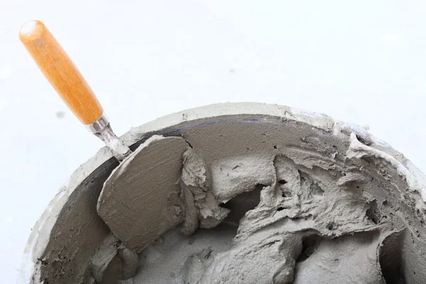 Dirty trowel and bucket on building site — Stock Photo, Image