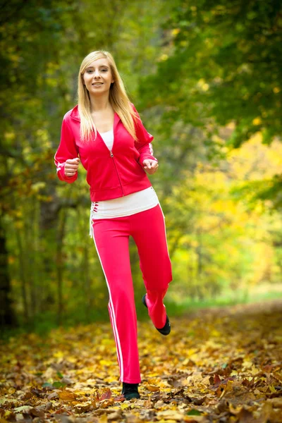 Femme courant dans la forêt d'automne. Entraînement des coureuses . — Photo