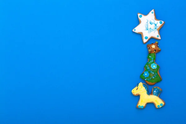 Gingerbread cake pony christmas tree star with icing decoration on blue — Stock Photo, Image