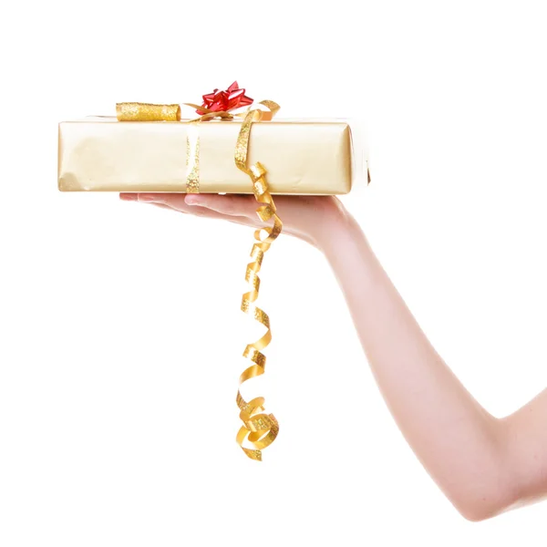 Mão feminina dando Natal caixa de presente de ouro com fita. Férias . — Fotografia de Stock