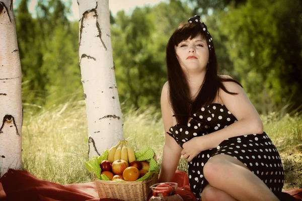 Picnic. Beautiful woman sitting on the blanket — Stock Photo, Image