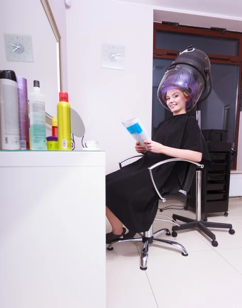 Rodillos de pelo mujer rulos lectura revista secador de pelo salón de belleza — Foto de Stock