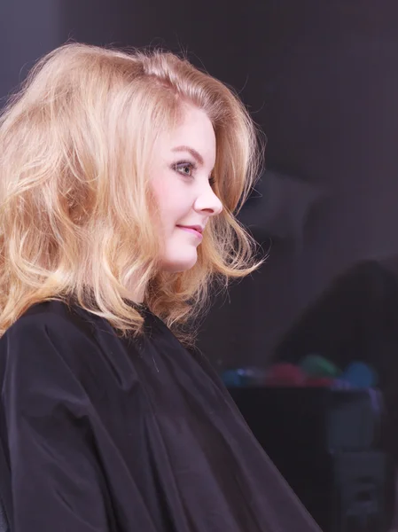 Mooi lachende meisje met blonde golvend haar door Kapper in beauty salon — Stockfoto