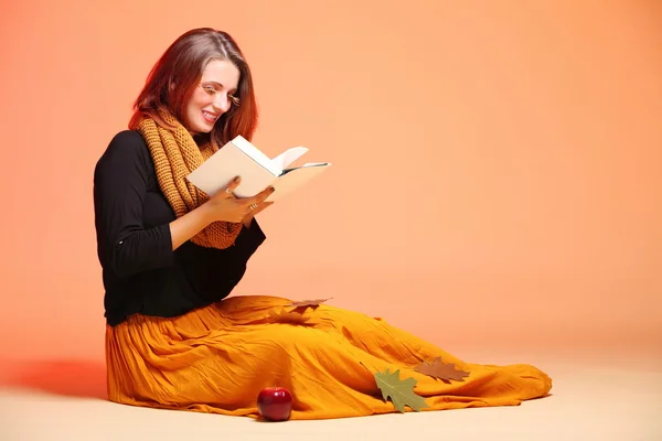 Otoño moda chica con libro naranja pestañas — Foto de Stock