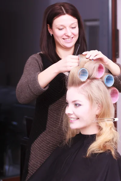 Schöne blonde Mädchen Lockenwickler Rollen Friseur Schönheitssalon Stockbild