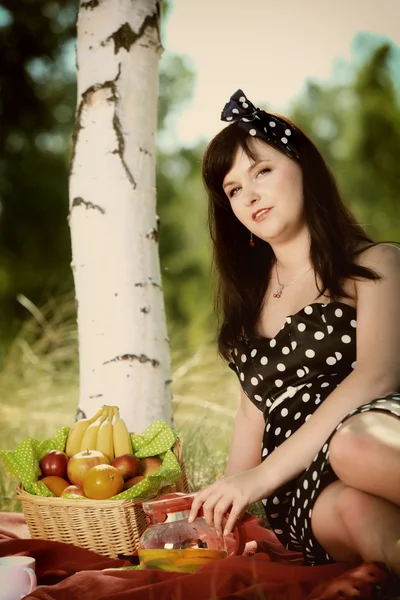 Piknik. piękna kobieta siedzi na koc — Zdjęcie stockowe
